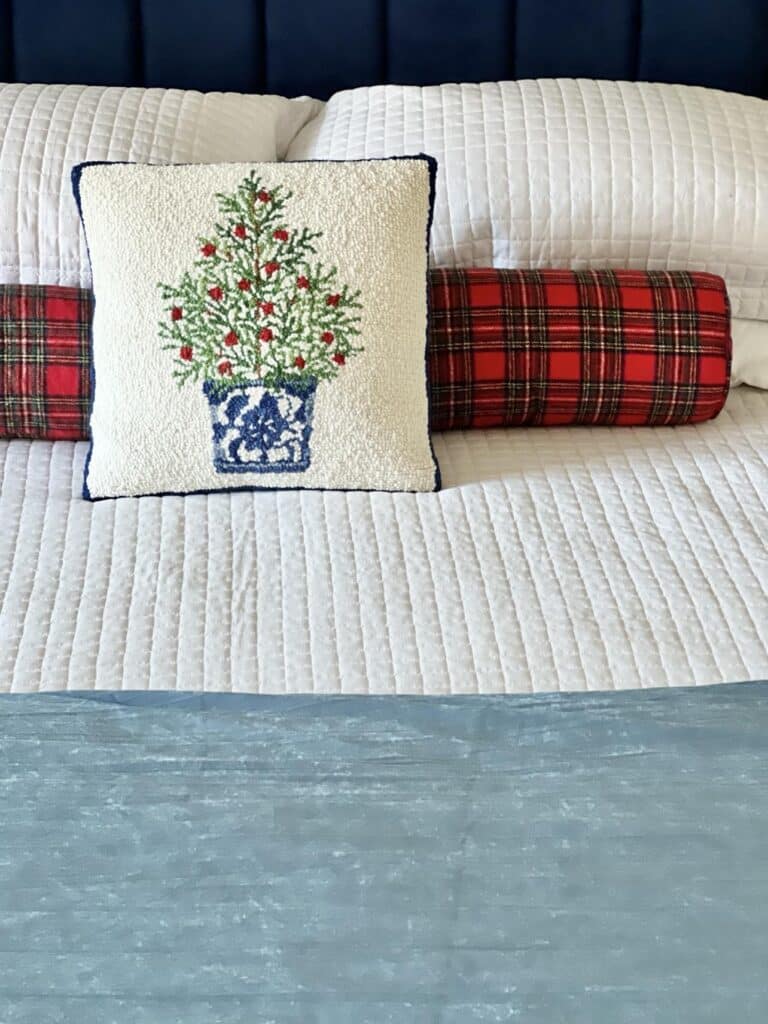 Planning for the holidays with a Christmas pillow on a bed.