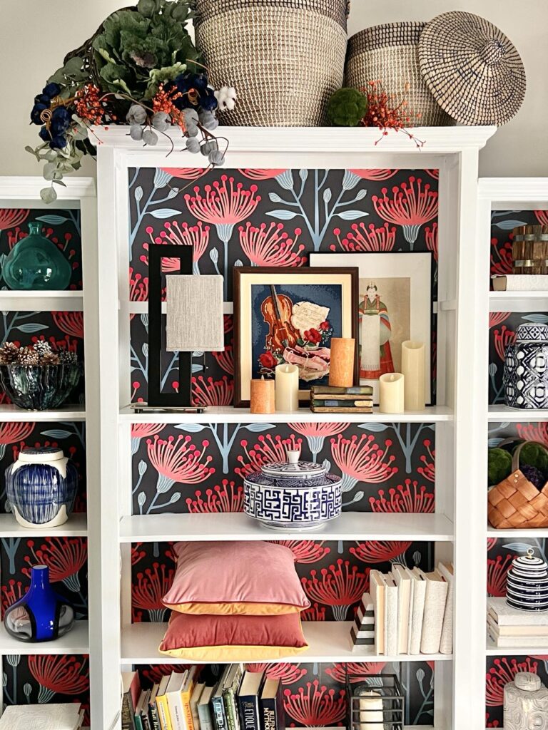 decorating bookshelves for fall with vibrant pinks, red, and blues.