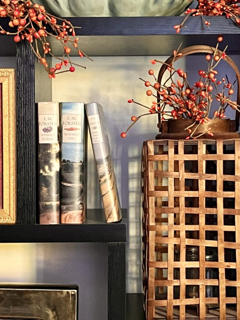 A woven wood lantern decorating bookshelves for fall.