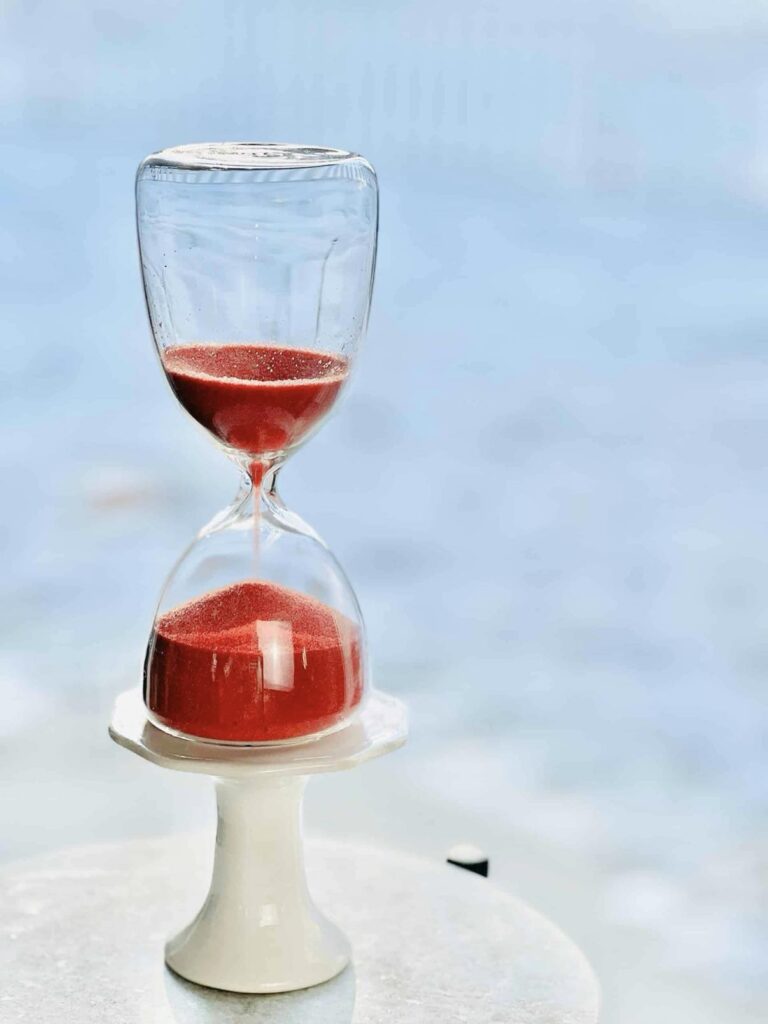 An hourglass with pink sand.