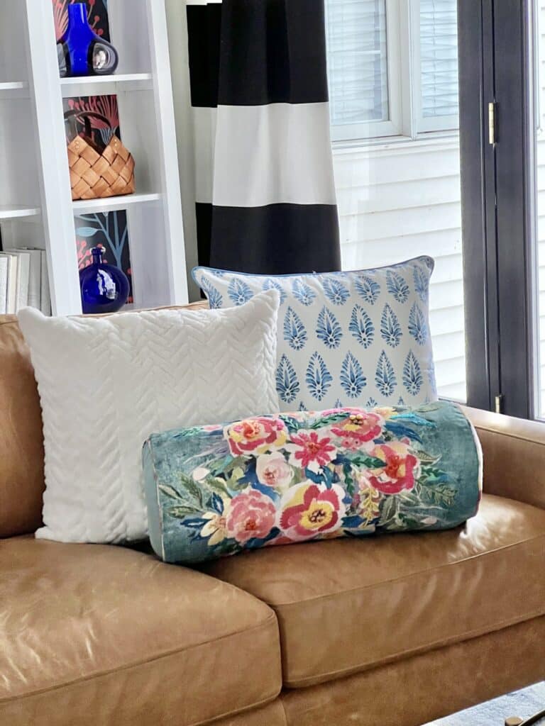 Knowing How to Clean Throw Pillows is important for these three throw pillows on a leather sofa.