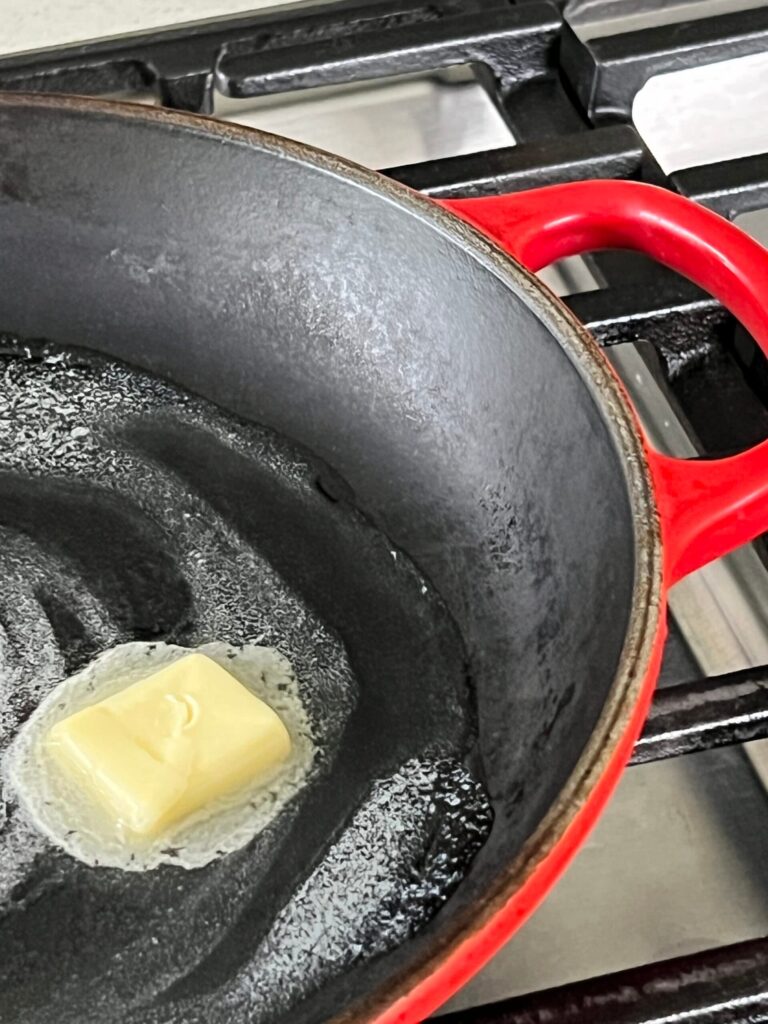 Melting butter in a skillet for a one- pan egg sandwich.