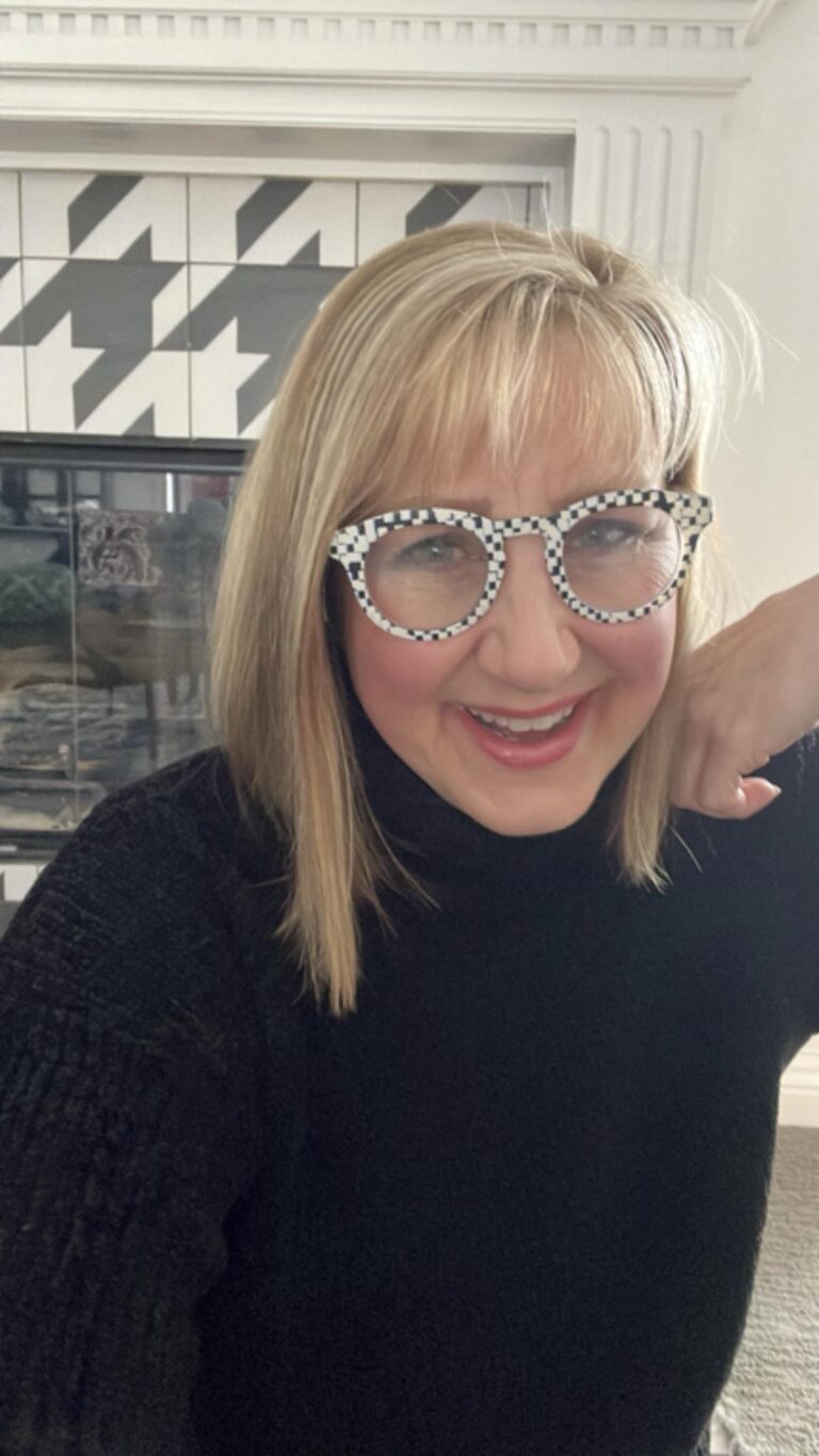 Woman wearing white and black reading glasses.