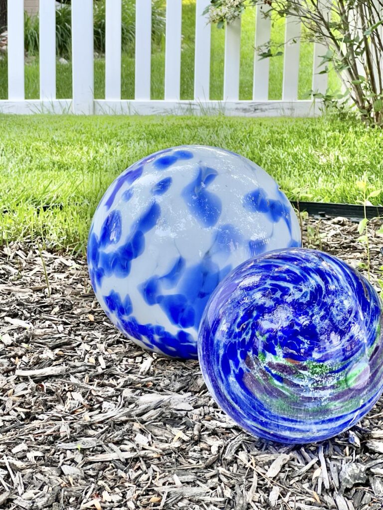Blue and white garden globe orbs in aa shade garden for color.