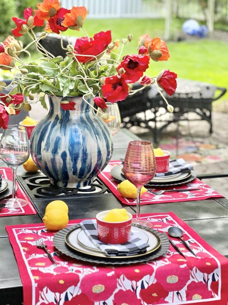 A vase of red poppies on a patriotic table setting and using the diy placemats that I made.