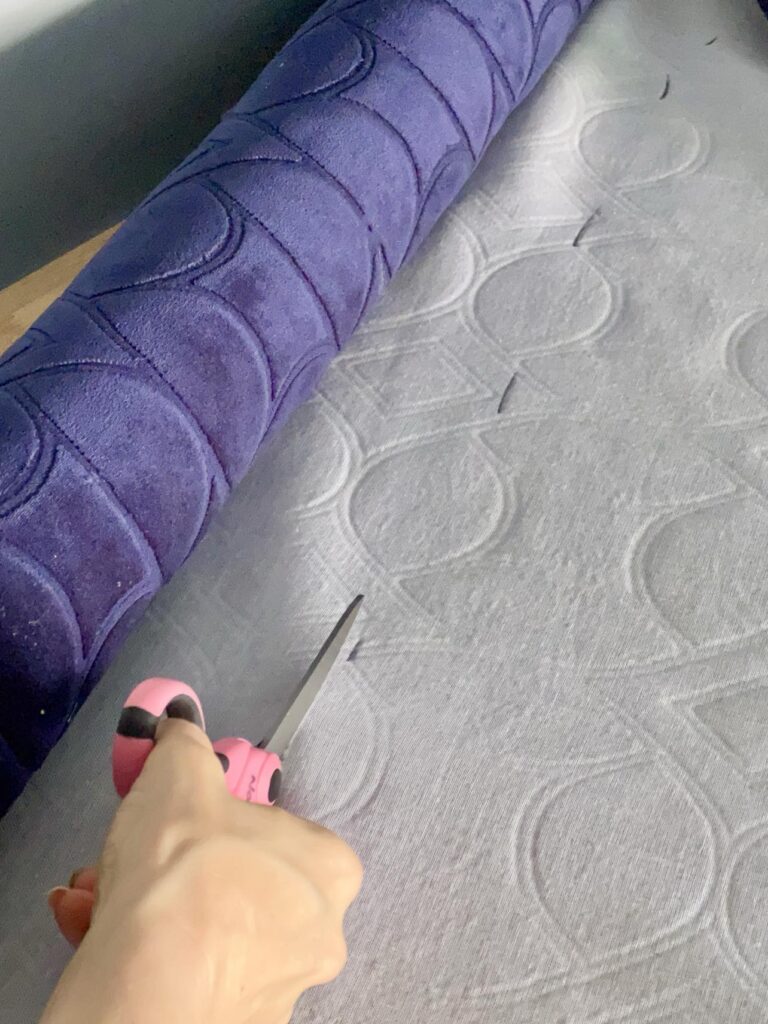 Cutting blue upholstery fabric for coffee table ottoman diy.