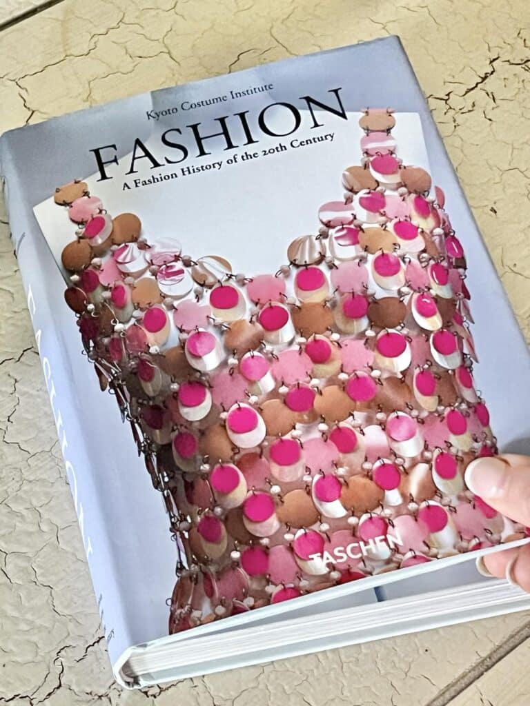 Decorating with Coffee Table Books with a Fashion book that has a pink and brown metal dress on the cover.