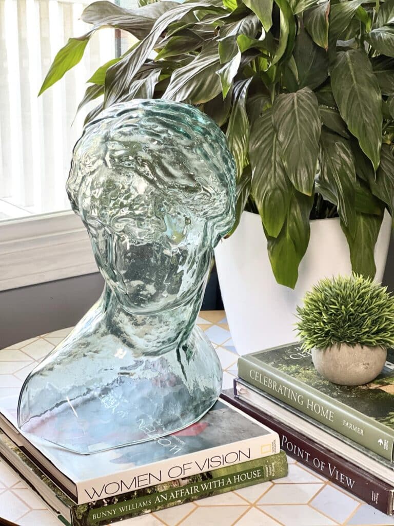 Decorating with Coffee Table Books: A glass bust sitting atop a stack of books.