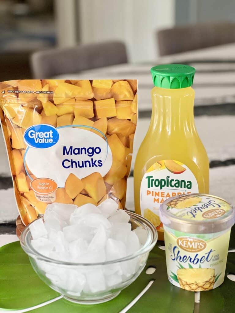 Ingredients for knowing for how to make mango a go go include a bag of frozen mango chunks, pineapple mango juice, pineapple sherbet, and a bowl of ice.