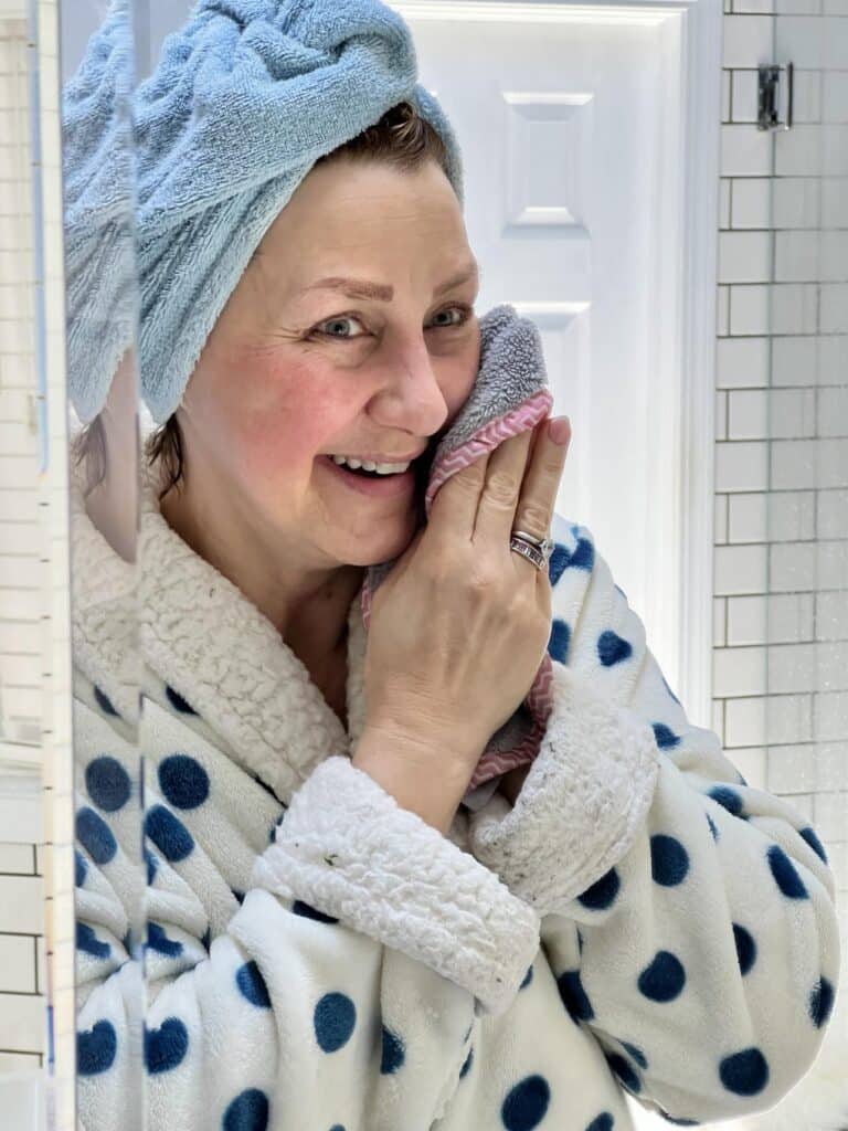A woman drying her face after care for her skin with face wash.