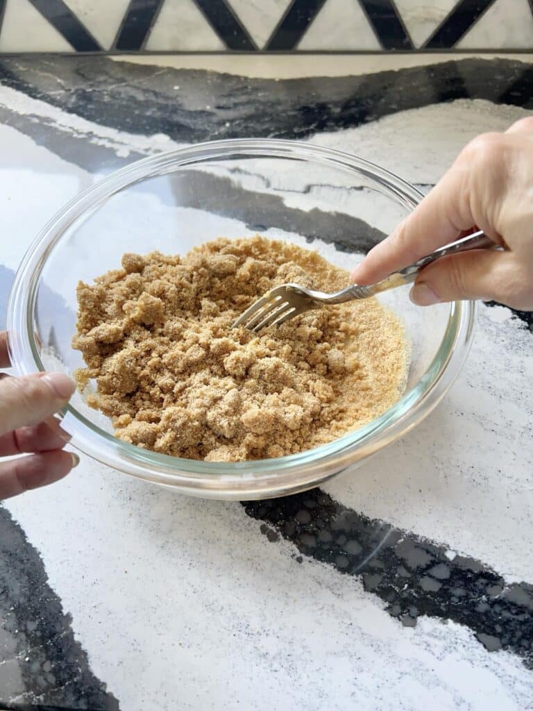 Mixing graham cracker crust ingredients with a fork.