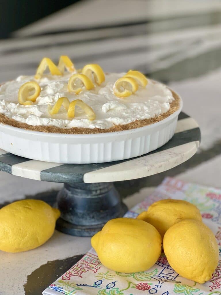 A no bake lemon curd pie sitting on a pedestal.