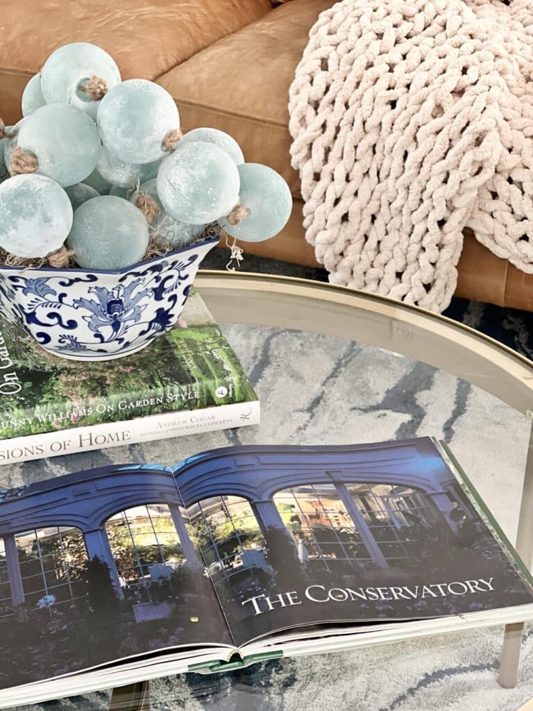 A coffee table decor book opened to a page that says "The Consevatory"