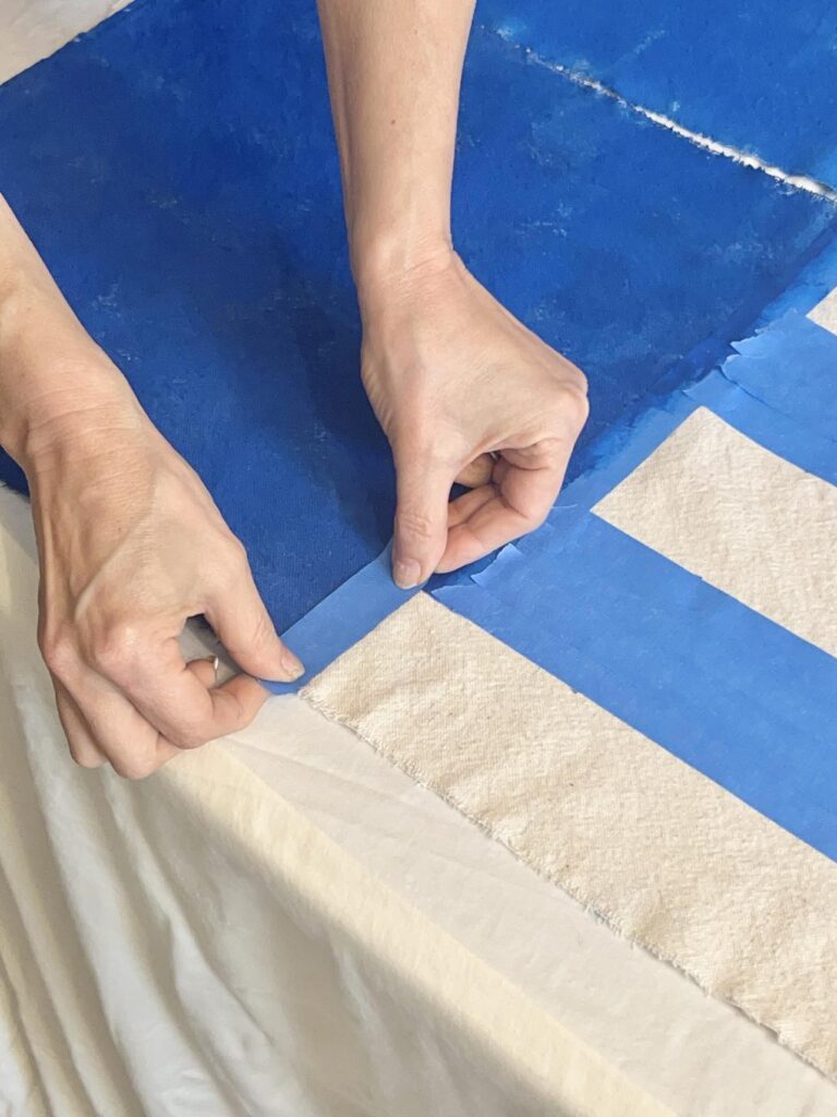 Adjusting blue tape on the fabric.