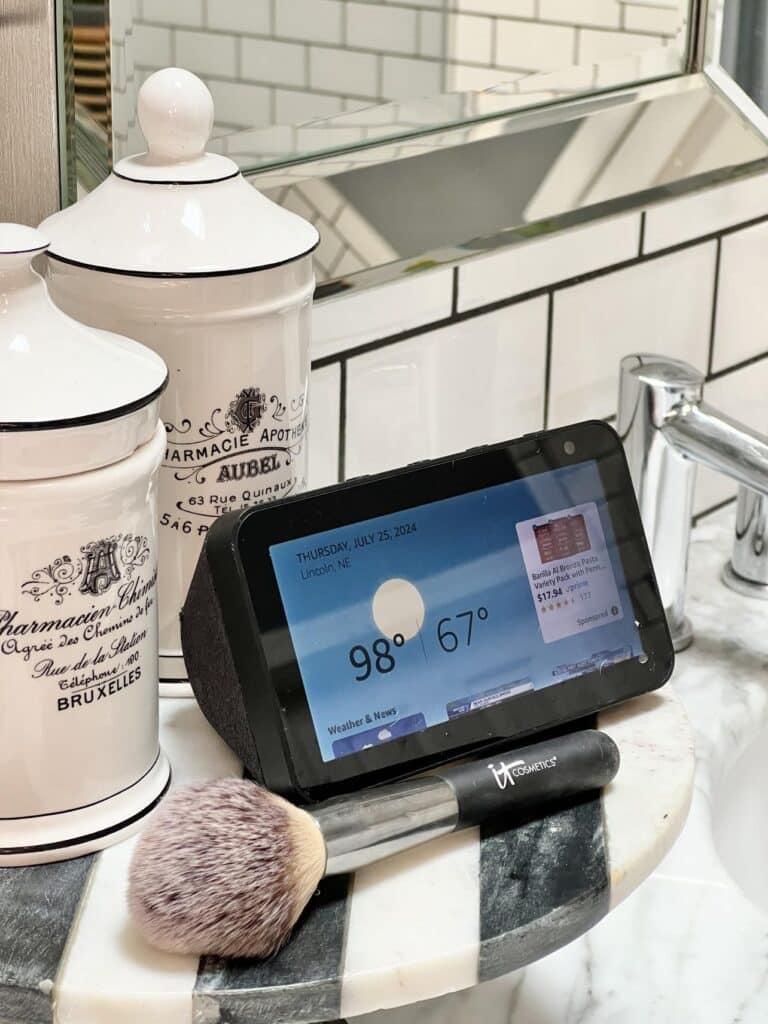 An "Alexa" on a bathroom pedestal tray on the countertop.