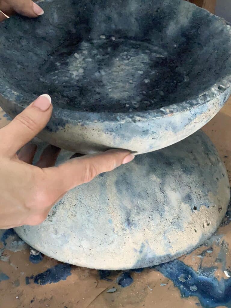 Placing the top concrete bowl on top of the concrete base.