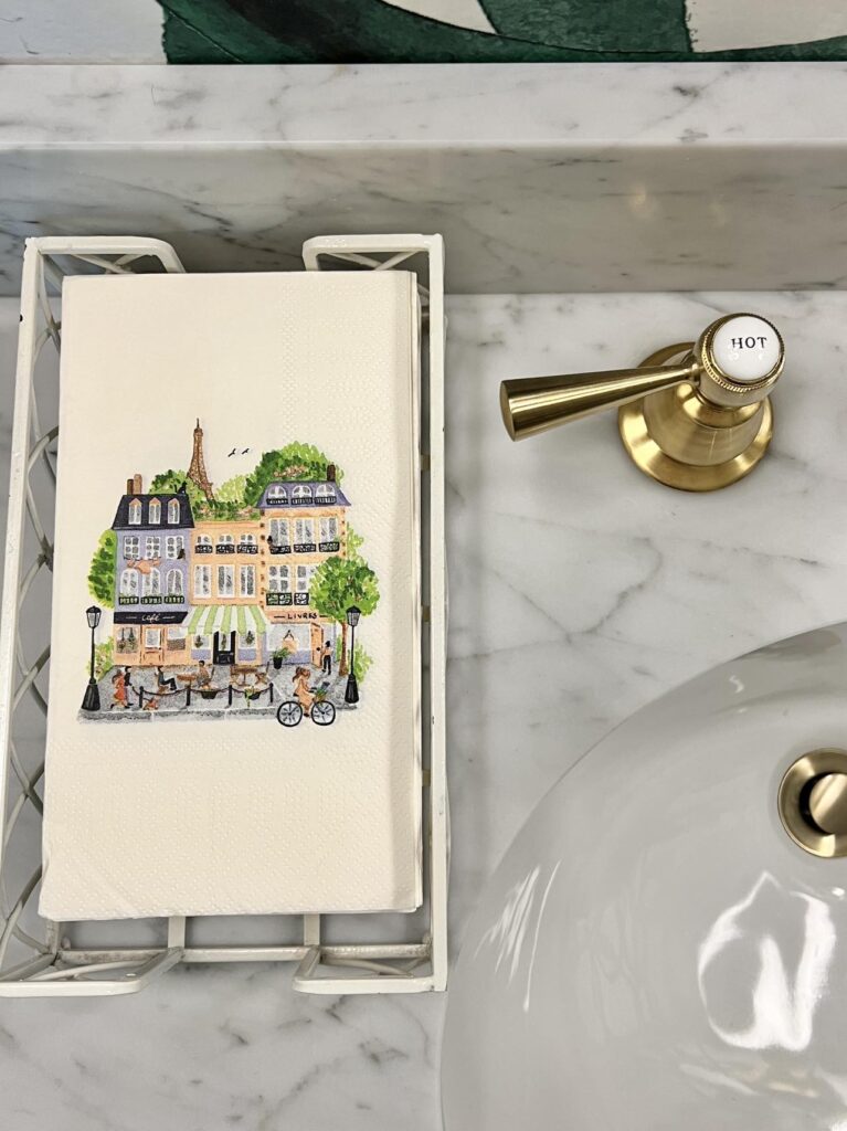 Paper guest towels printed with home facades decorates a guest powder room countertop.