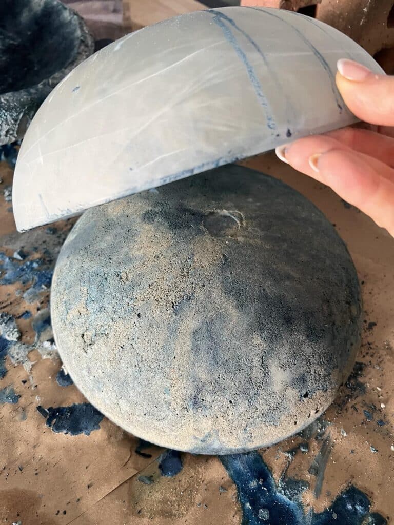 Removing a glass fixture cover to reveal the base of a DIY concrete bowl.