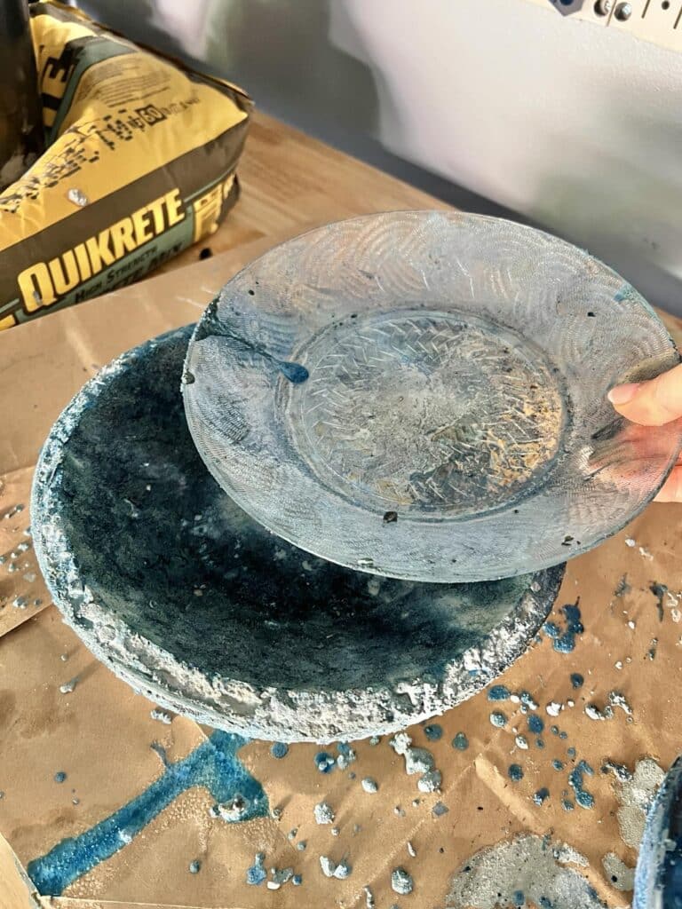 Removing the glass plate from the top of the DIY concrete bowl.