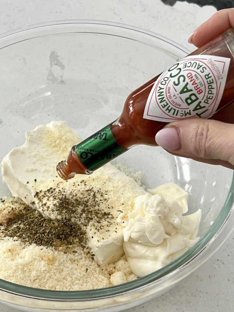 Adding a dash of Tabasco hot sauce to the spinach artichoke dip mixture.