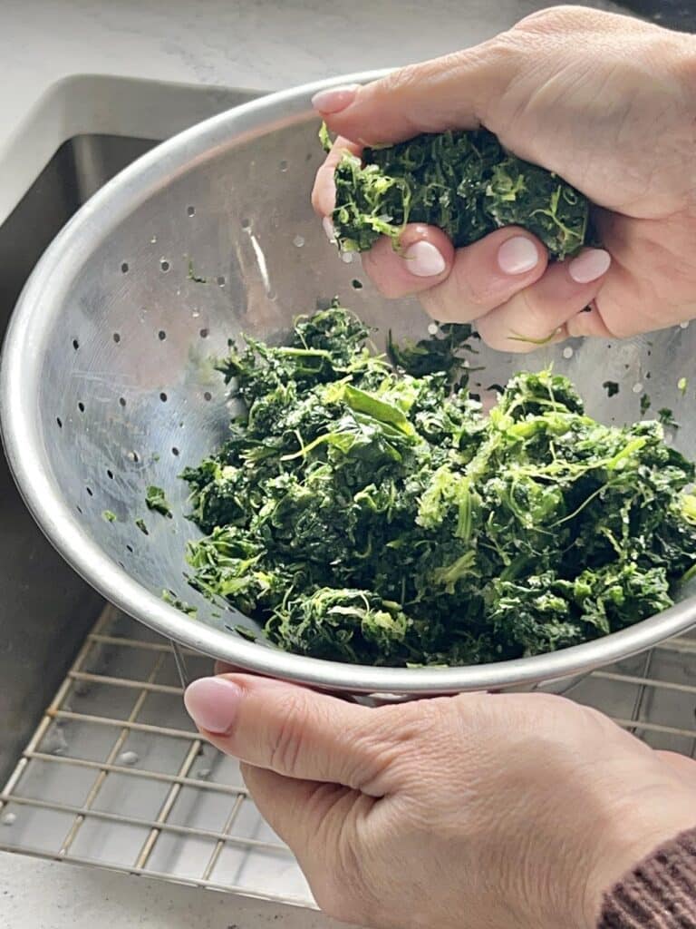 Squeezing out excess moisture from frozen spinach.