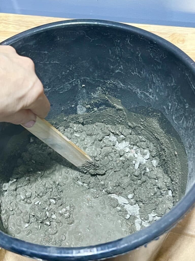 Mixing concrete mix and water for a DIY bowl base.