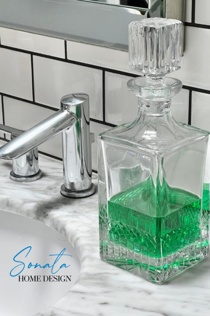 Bathroom countertop decor ideas with a glass decanter holding mouthwash.