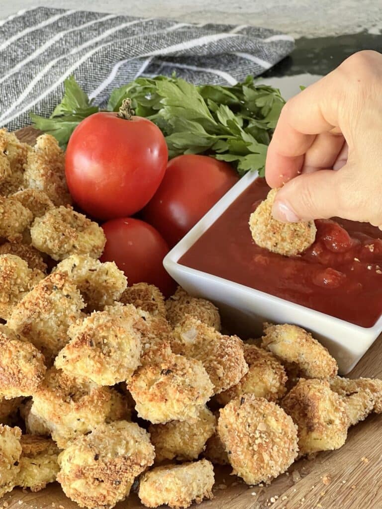 Dipping tortellini bites into marinara sauce.