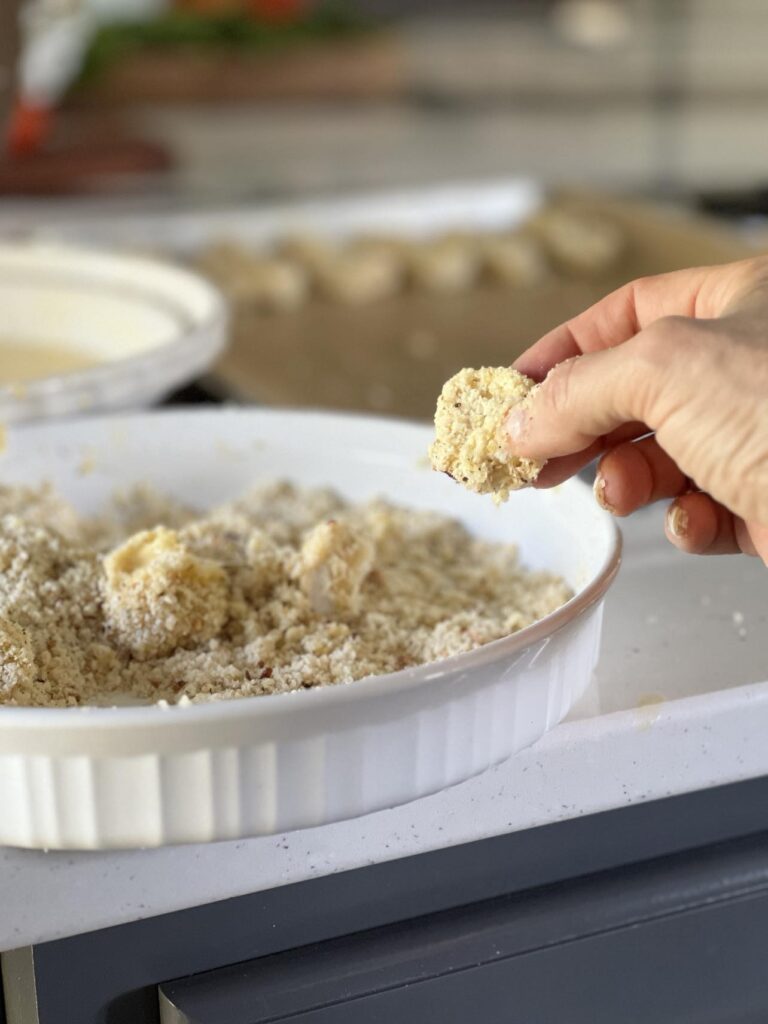 Breading tortellini in parmesan crumb mixture.