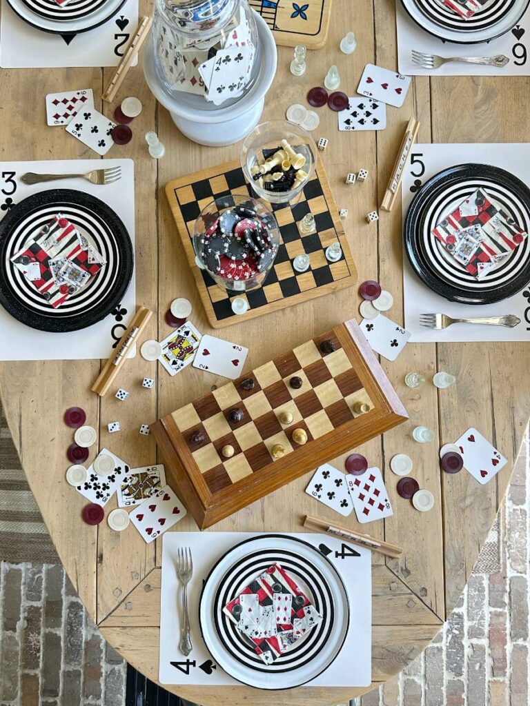 Game cards and a checkerboard on top of a table setting by Vintage Home Designs.