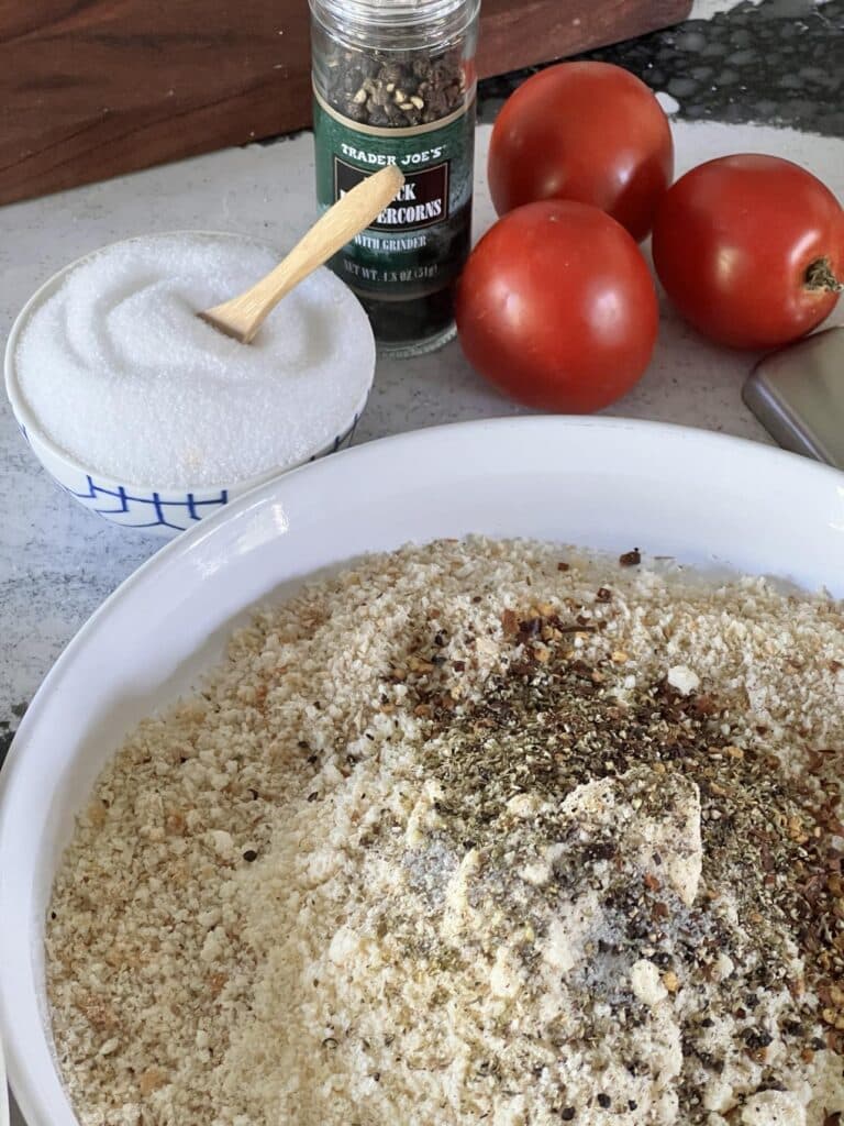 Bread crumbs and parmesan with spices in a shallow dish.