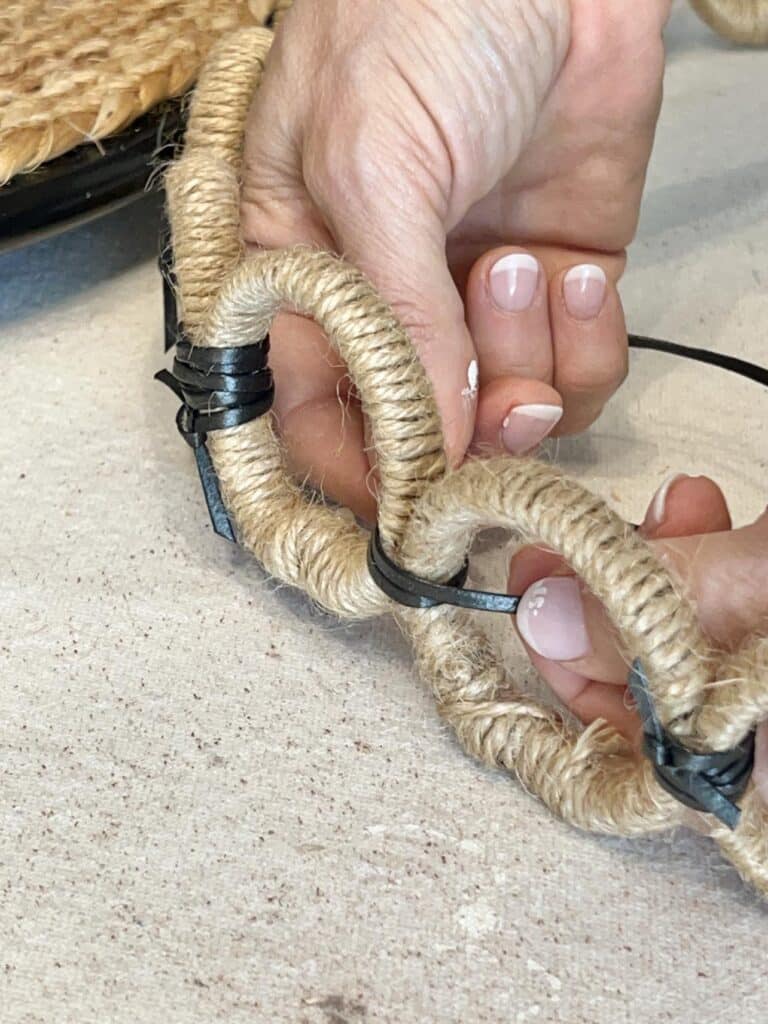 Tying together jute covered curtain rings with leather lacing for DIY lazy Susan scallops.