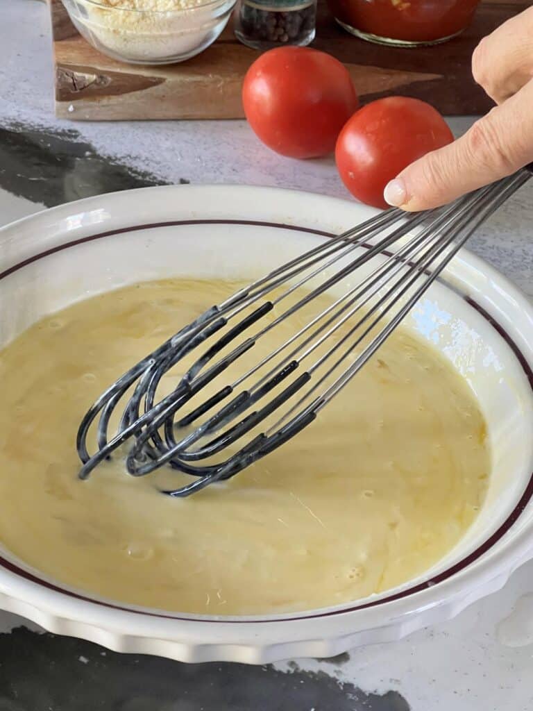 Whisking an egg mixture for the tortellini bites.