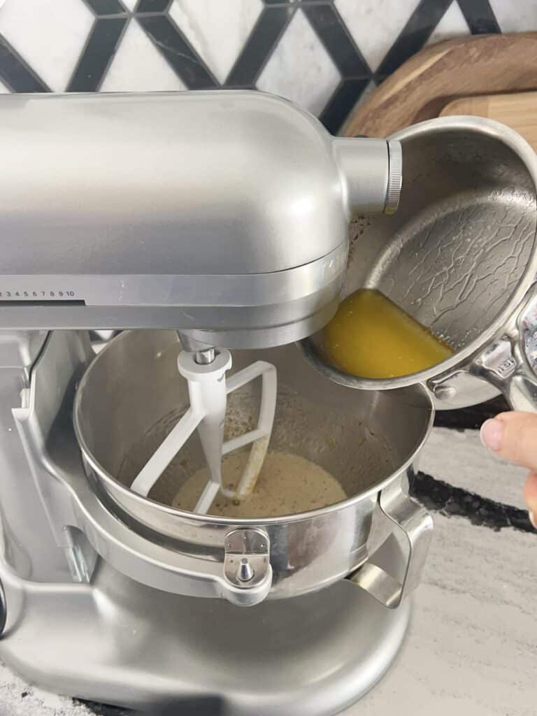 Adding melted butter to stand mixer.