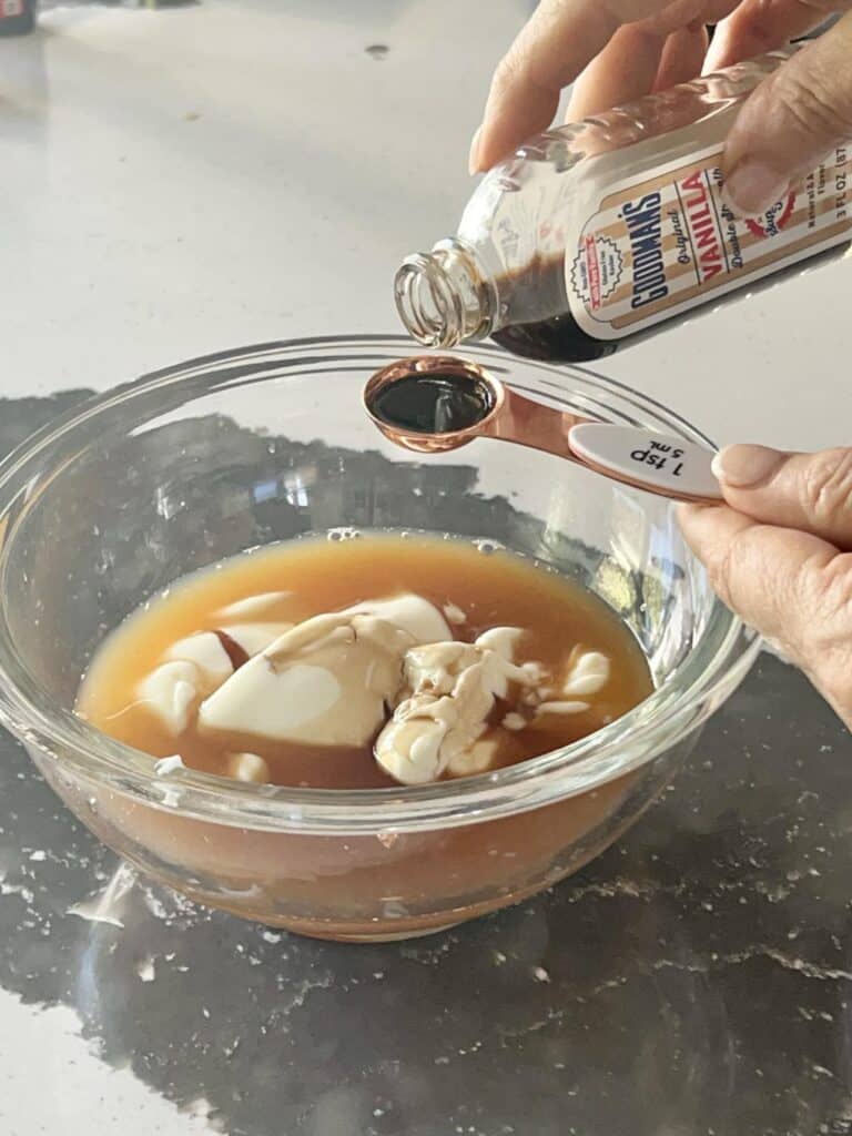 Adding vanilla to the wet ingredients for theapple cider donut bread rrecipe.