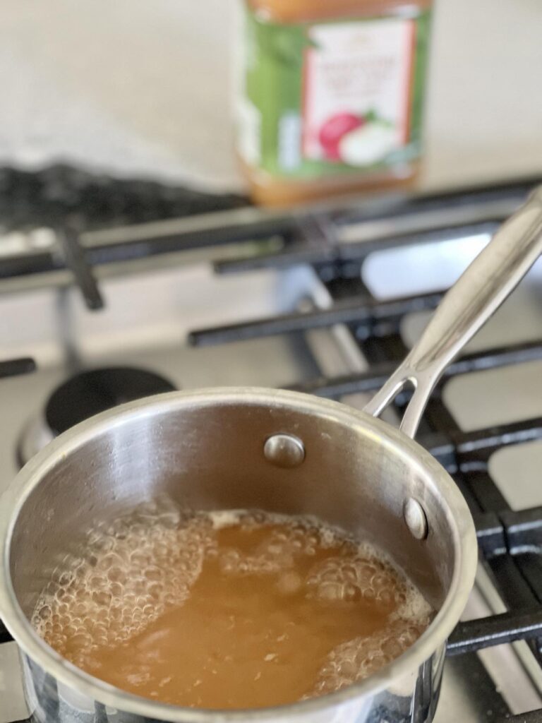 Boiling apple cider for thedoughnut bread recipe.