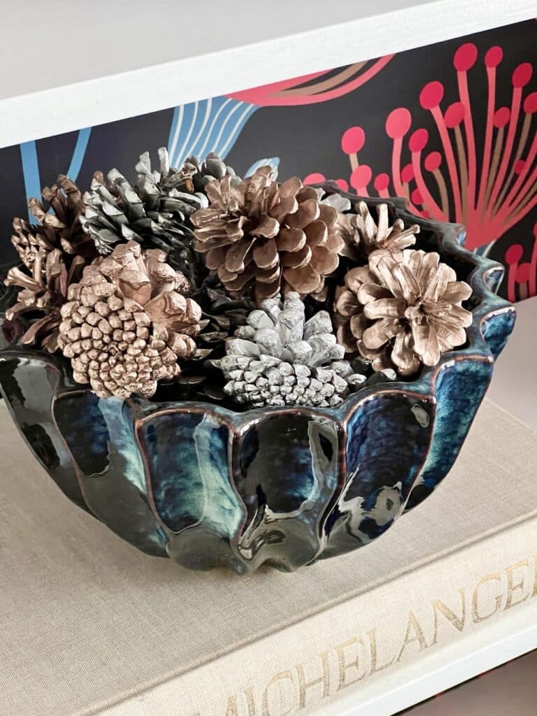 fall living room decorating ideas include pine cones filling a glazed decor bowl.