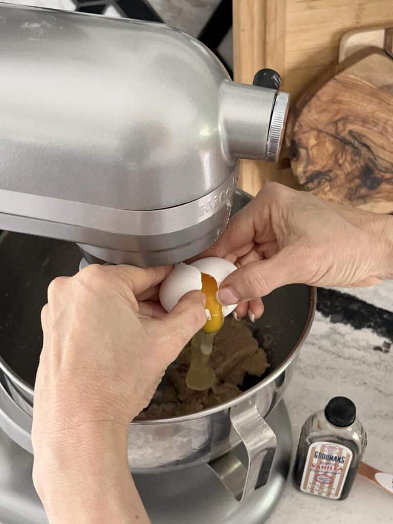 Cracking an egg into a stand mixer.