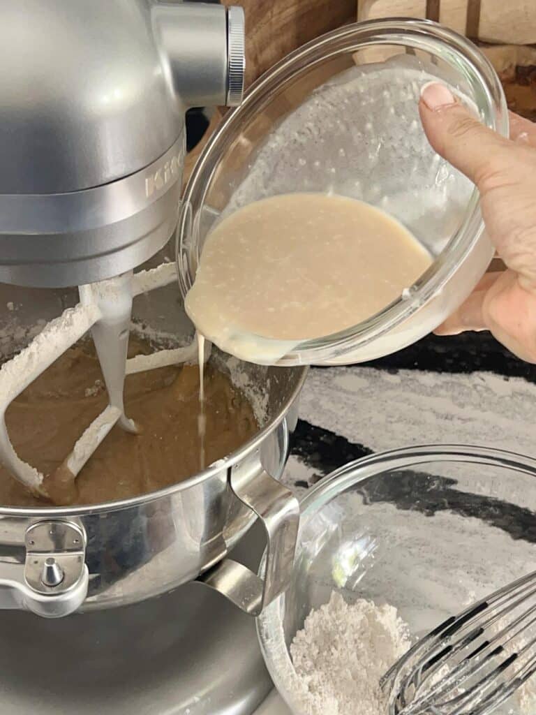 Pouring wet batter into stand mixture.