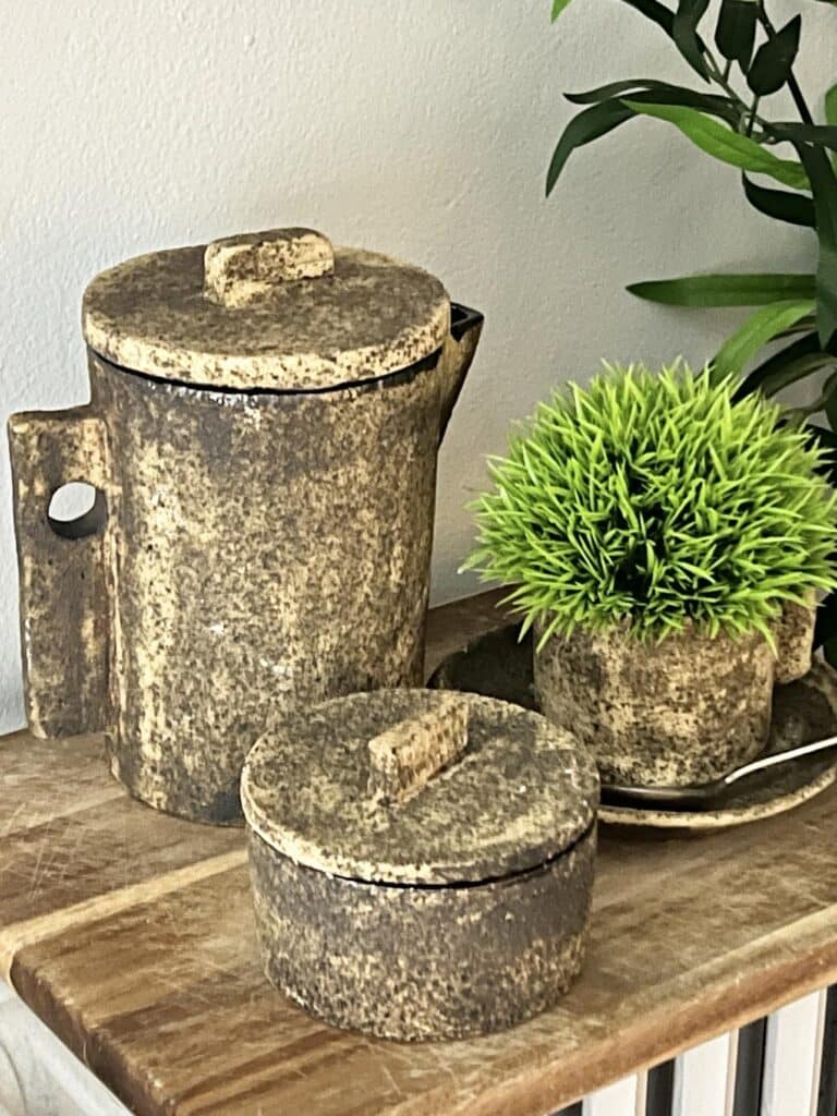 A coffee set with faux green plant that was found at the chelsea flea market manhattan.