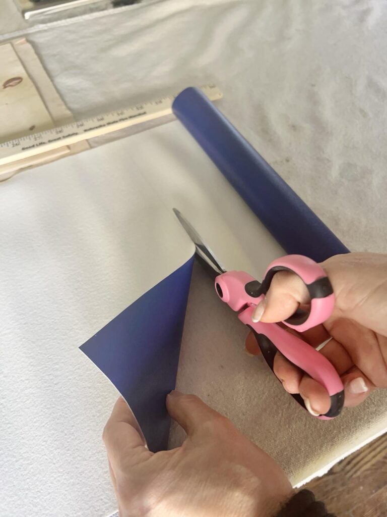 Cutting a piece of faux leather with scissors.