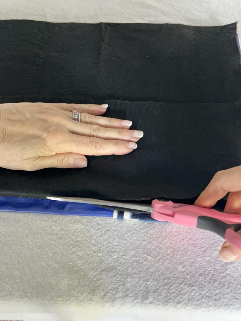 Cutting black felt with scissors.