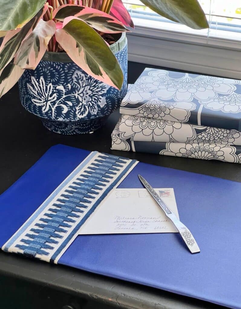 A diy desk pad on a black desk with a letter and letter opener.