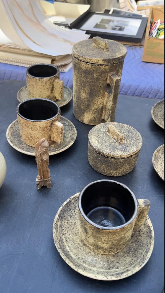 A coffee pot, sugar pot, and cups found at the chelsea flea market in manhattan.