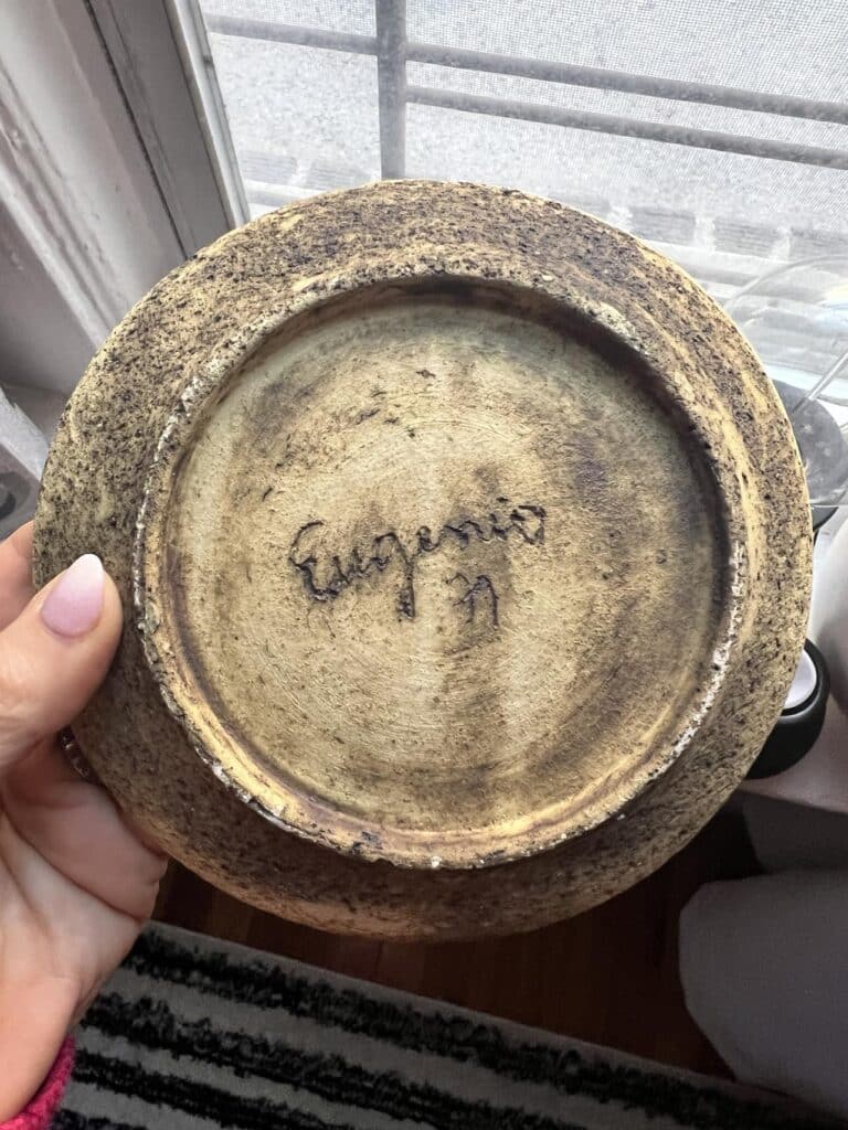 The bottom of a cup signed "Eugenia"