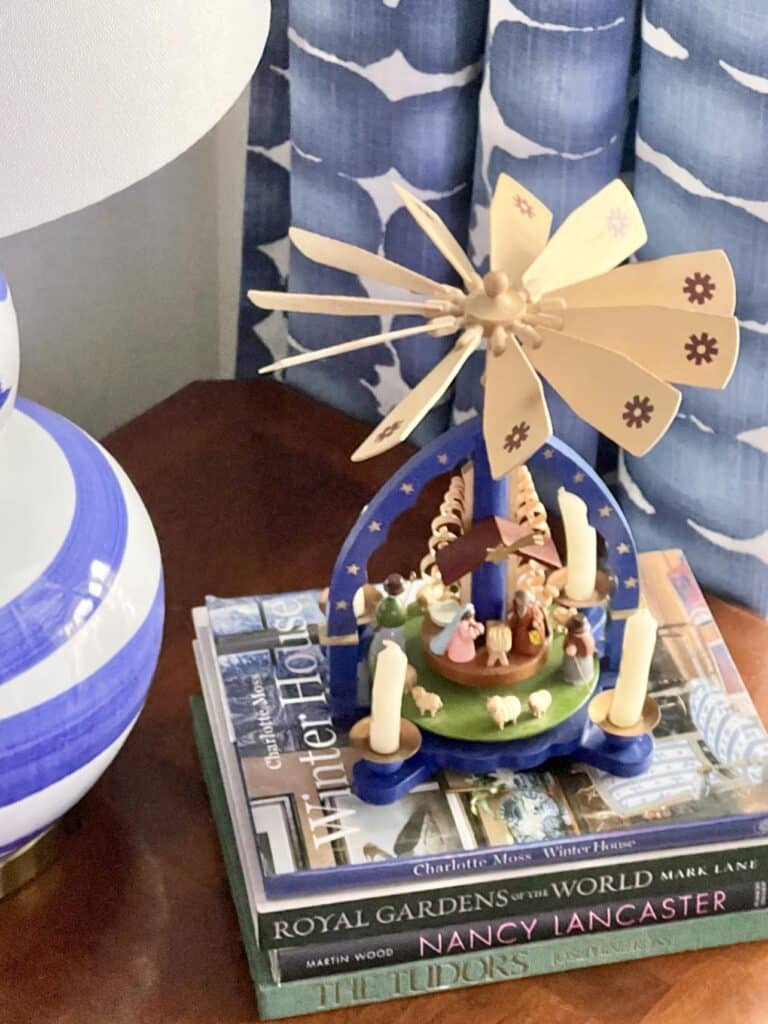 An alpine spinner sitting on top of a stack of books as part of a Christmas home tour.