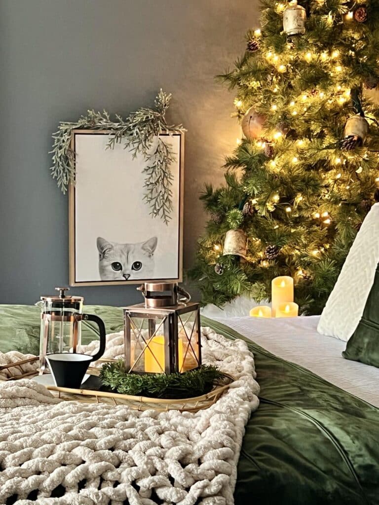 A bed with a coverlet, throw blanket, and welcoming tray for a cozy Christmas bedroom.