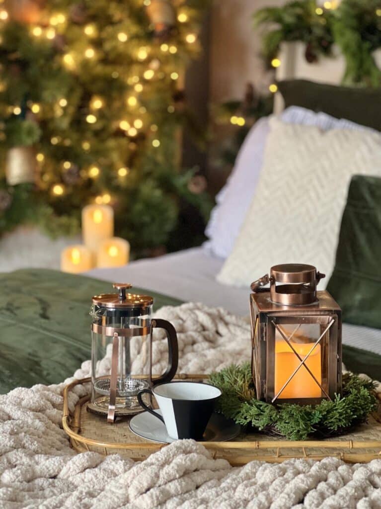 cozy Christmas bedroom ideas include this tray with a copper lantern and a French press coffee maker.