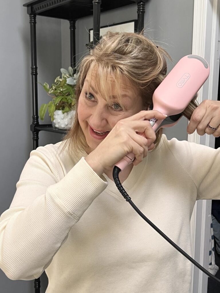 How to use a hair waver: woman clamping a hair waver tool close to her scap.