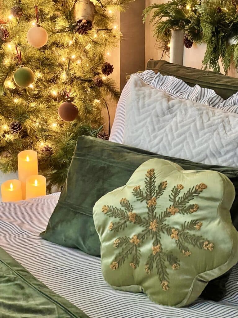 Green pine cone pillow decorating a cozy Christmas bedroom.